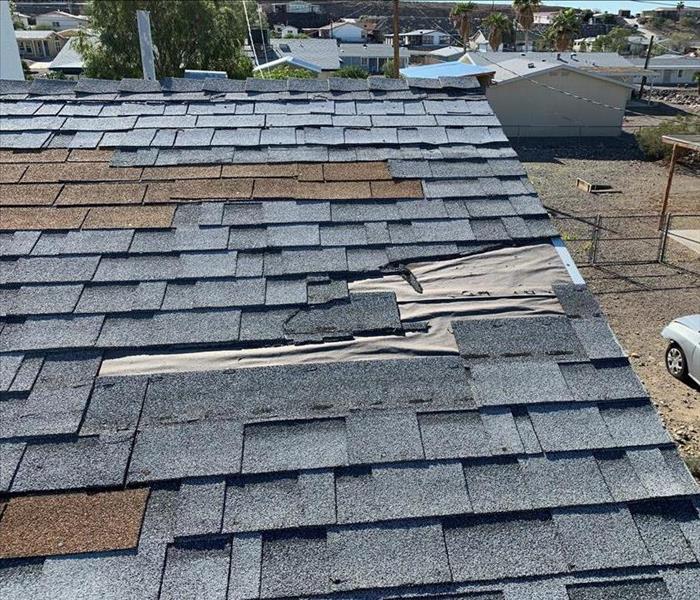 Damaged roof shingles on a roof of a home. 