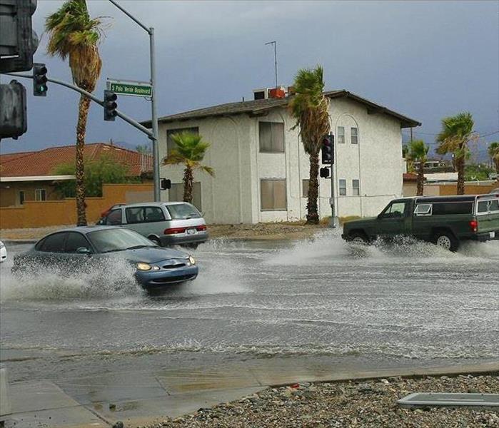 A couple inches of water flooded streets in Lake Havasu City Arizona.  Vehicles driving and splashing water from the tires