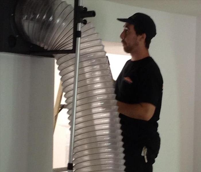SERVPRO Tech Performing Professional Duct Cleaning using our Large Safe Self Contained Suction Method
